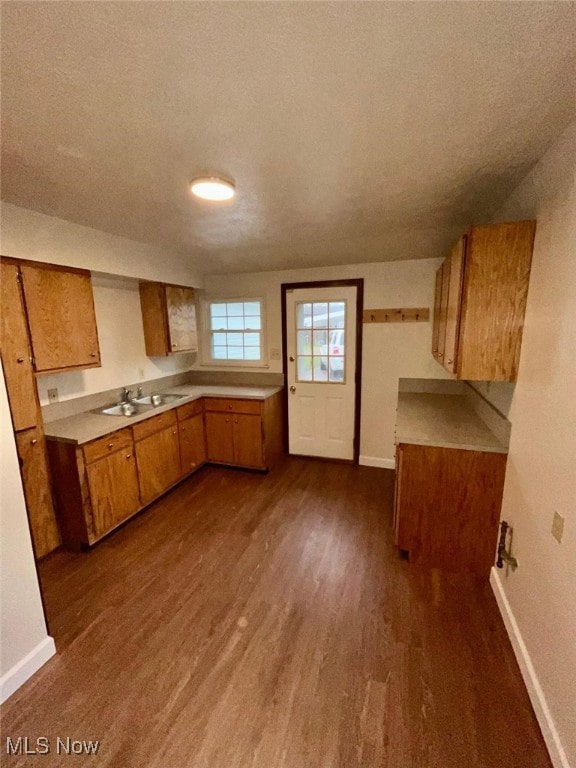 kitchen with a textured ceiling, dark hardwood / wood-style flooring, and sink