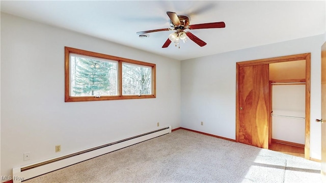 unfurnished bedroom featuring ceiling fan, a closet, light colored carpet, and a baseboard heating unit