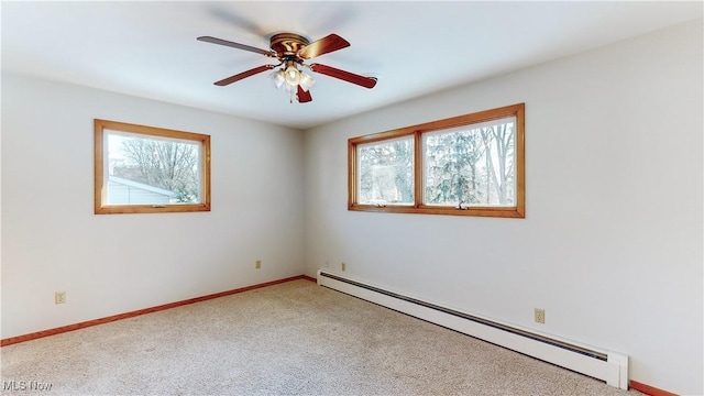 carpeted spare room with ceiling fan and a baseboard radiator