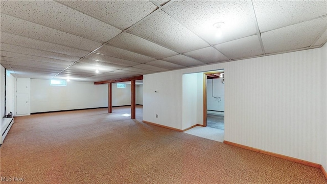 basement featuring a paneled ceiling, carpet floors, and baseboard heating