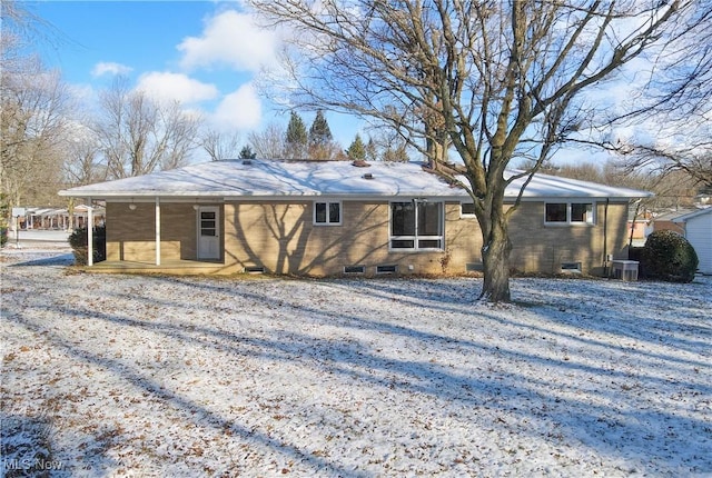 snow covered property with central AC unit