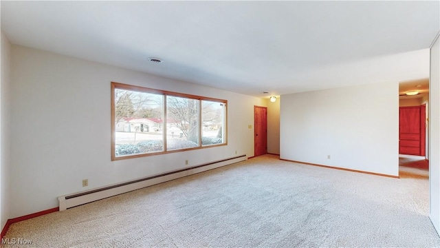 spare room featuring carpet flooring and a baseboard heating unit