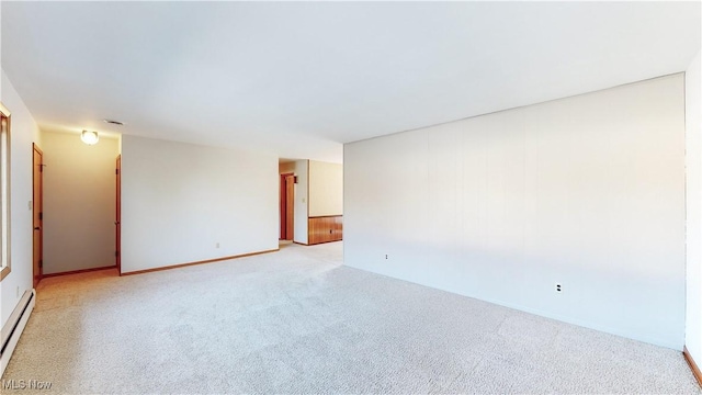 carpeted spare room featuring a baseboard heating unit