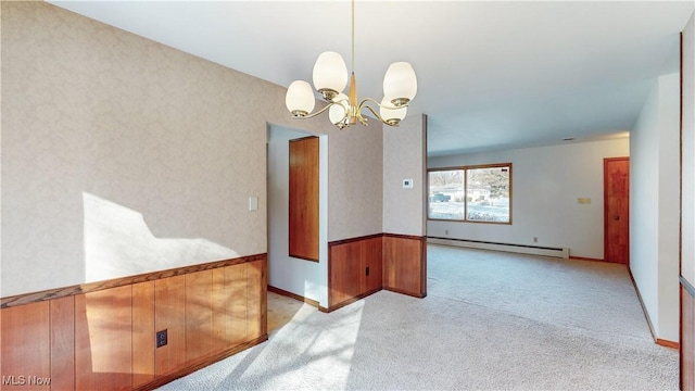 spare room featuring light colored carpet, baseboard heating, and a chandelier