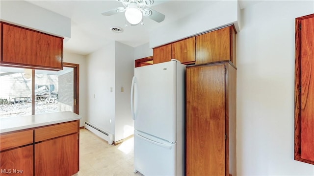 kitchen with ceiling fan, white fridge, and a baseboard radiator