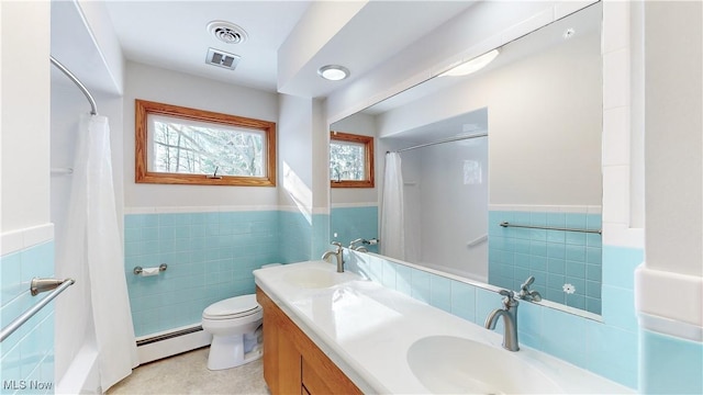 bathroom featuring tile patterned floors, vanity, a baseboard radiator, tile walls, and toilet