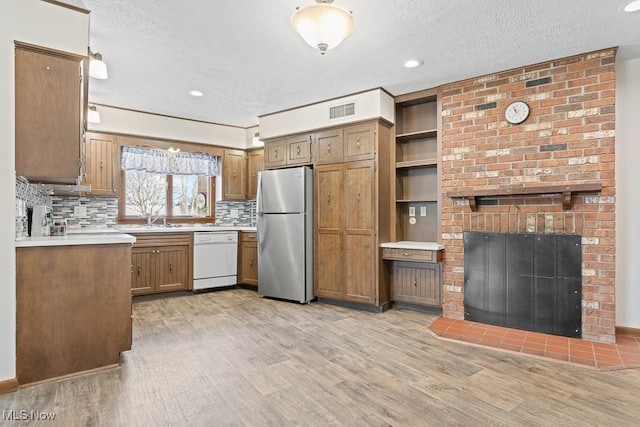 kitchen featuring stainless steel fridge, a textured ceiling, white dishwasher, and light hardwood / wood-style floors