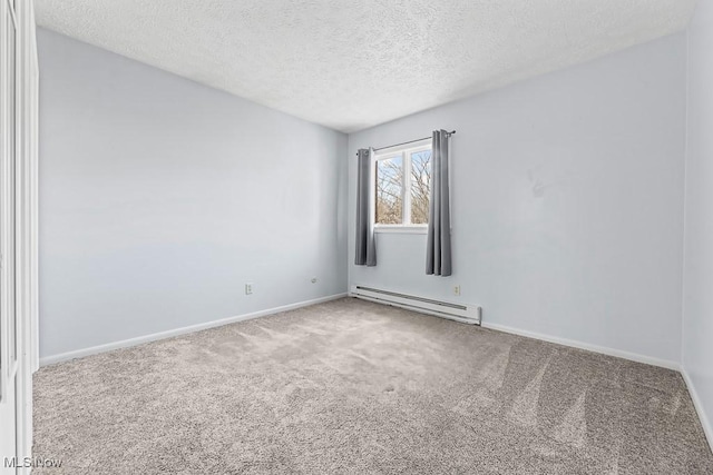 spare room featuring a textured ceiling, carpet floors, and a baseboard heating unit