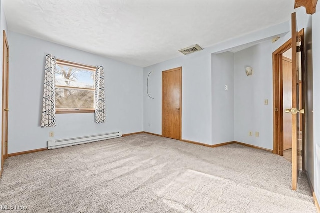 carpeted empty room with a baseboard heating unit