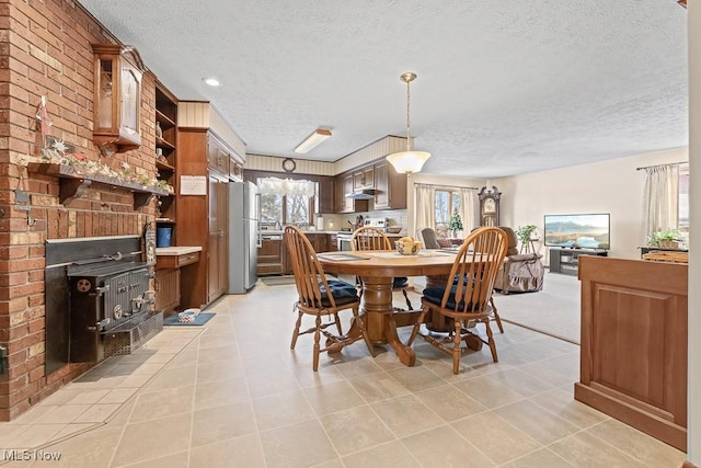 dining room with light tile patterned floors, a textured ceiling, and plenty of natural light