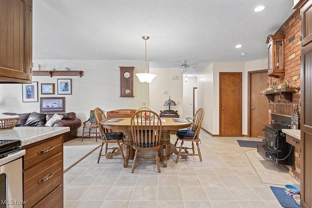 tiled dining area with a wood stove and ceiling fan