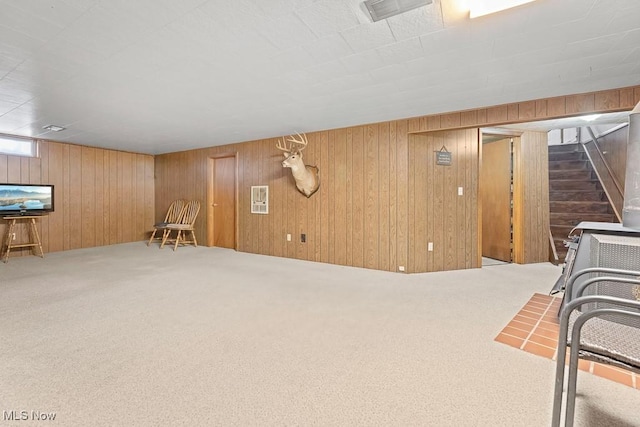 basement with carpet and wooden walls