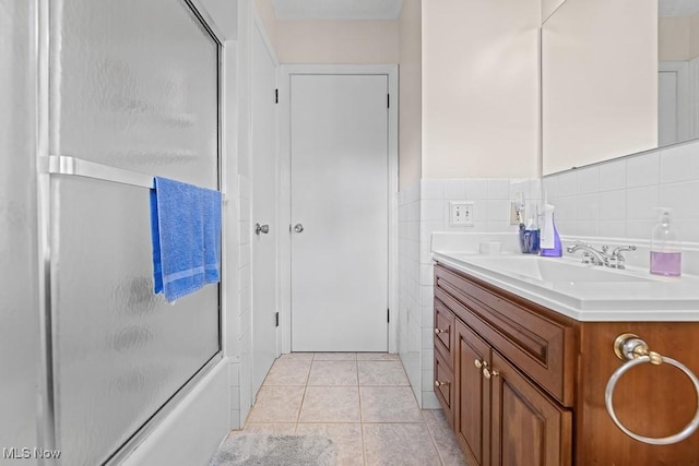 bathroom with tile patterned flooring, vanity, and bath / shower combo with glass door