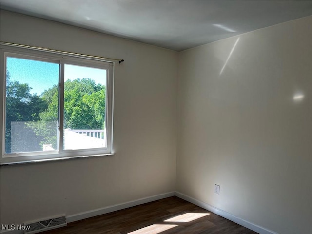 spare room with dark wood-type flooring