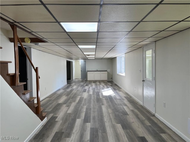 basement featuring dark hardwood / wood-style flooring and a paneled ceiling