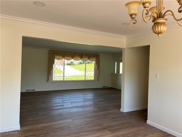 unfurnished room with a chandelier, crown molding, and dark wood-type flooring