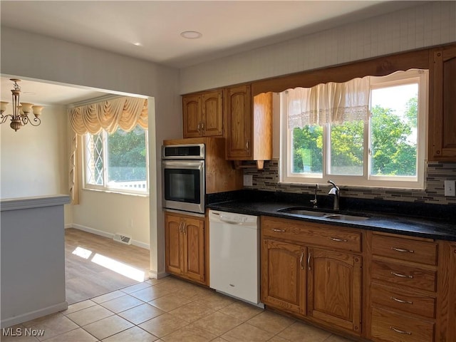 kitchen featuring white dishwasher, oven, a healthy amount of sunlight, and sink