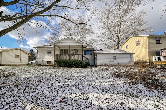 snow covered rear of property with a porch