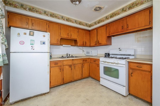 kitchen featuring decorative backsplash, sink, and white appliances