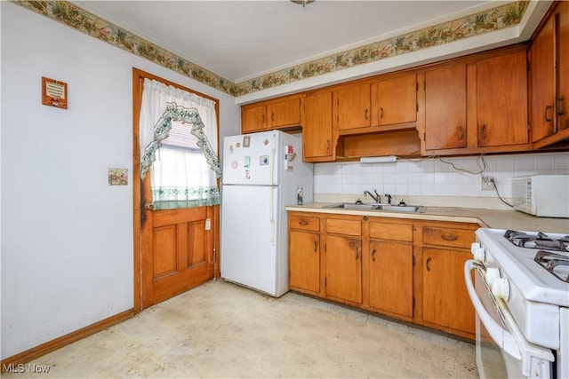 kitchen with backsplash, white appliances, and sink