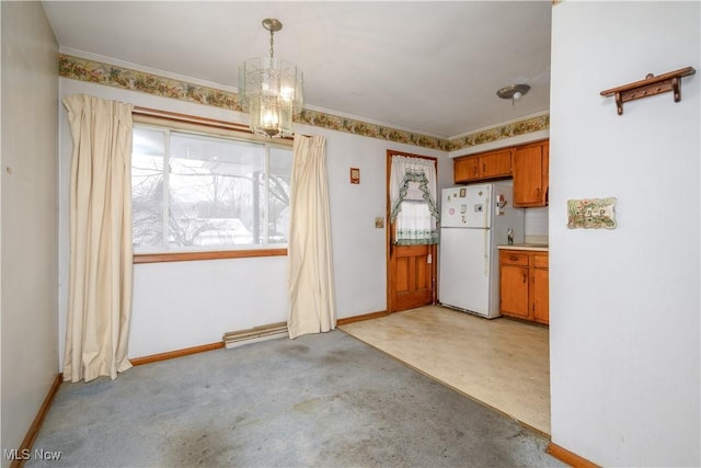 unfurnished dining area with light colored carpet, ornamental molding, a baseboard radiator, and a chandelier