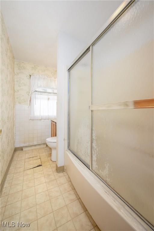 bathroom with shower / bath combination with glass door and toilet