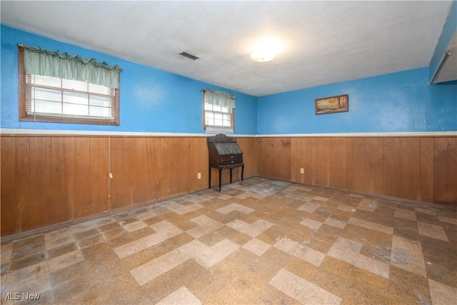 empty room featuring wood walls