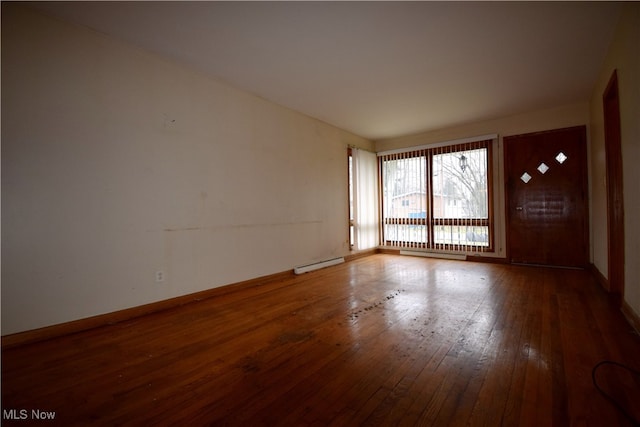 empty room with wood-type flooring and baseboard heating