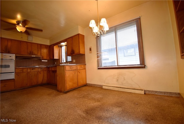 kitchen with stainless steel oven, hanging light fixtures, baseboard heating, tasteful backsplash, and ceiling fan with notable chandelier