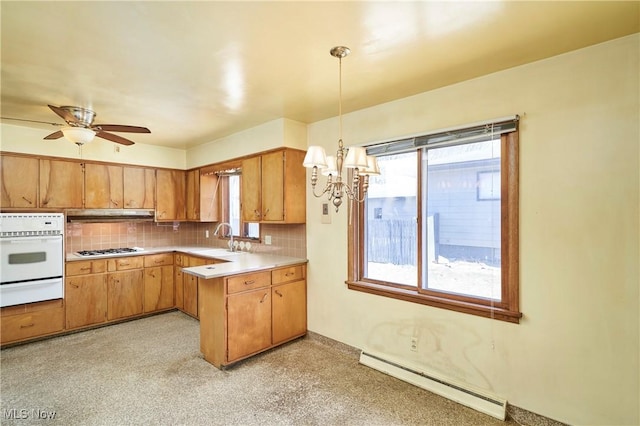 kitchen featuring light countertops, stainless steel gas stovetop, a baseboard heating unit, white oven, and tasteful backsplash