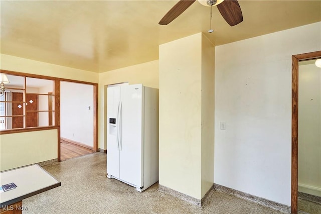 empty room featuring speckled floor, baseboards, and ceiling fan