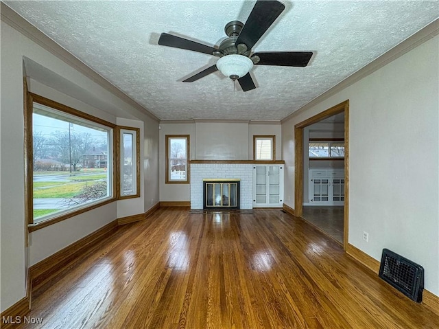 unfurnished living room with ceiling fan, a fireplace, a textured ceiling, and hardwood / wood-style flooring