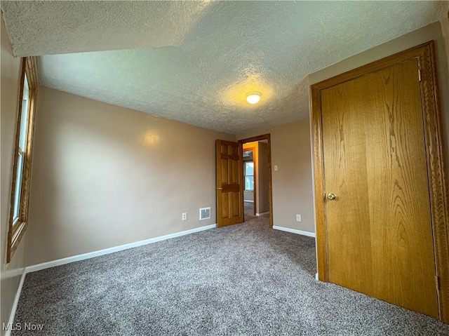 unfurnished bedroom featuring carpet floors and a textured ceiling