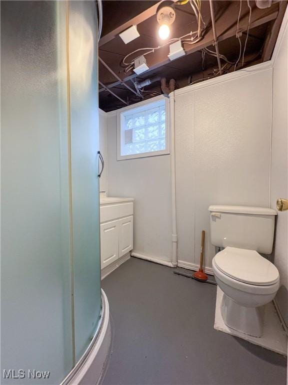 bathroom featuring concrete flooring, vanity, an enclosed shower, and toilet