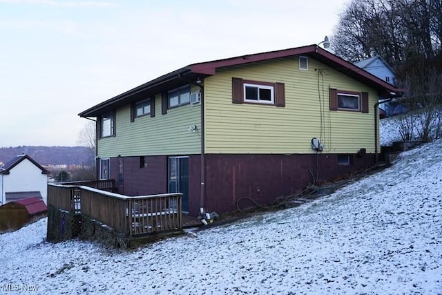 view of snow covered exterior with a wooden deck