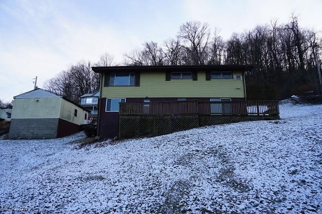 snow covered property with a wooden deck