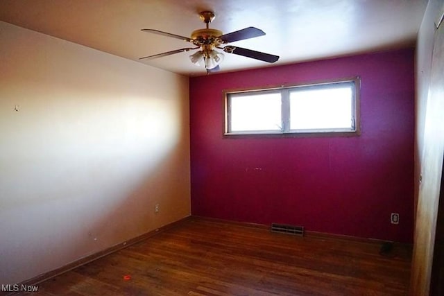 empty room with ceiling fan and dark wood-type flooring