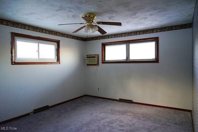 carpeted spare room with an AC wall unit and ceiling fan