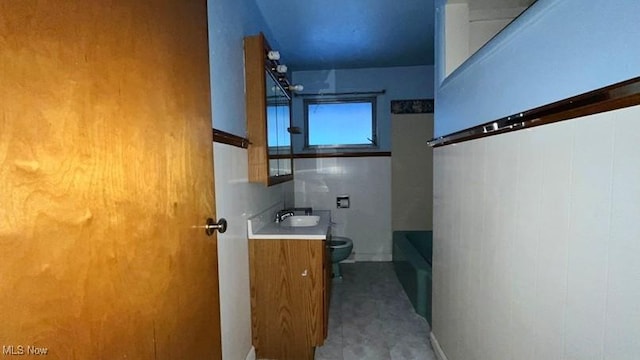 bathroom featuring vanity, toilet, and a tub