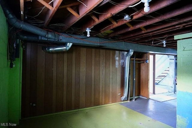 basement featuring wooden walls