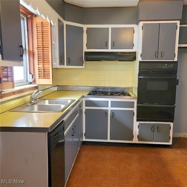 kitchen featuring under cabinet range hood, gray cabinetry, black appliances, a sink, and a warming drawer