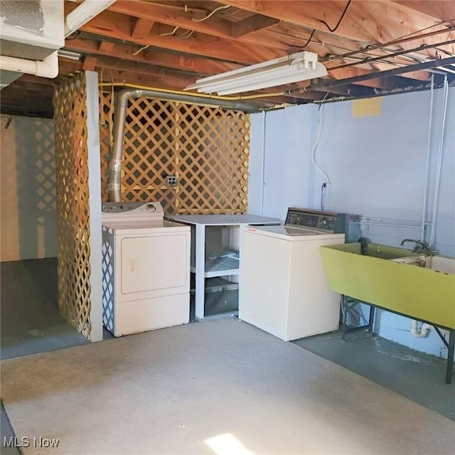 unfinished basement featuring washer and clothes dryer and a sink