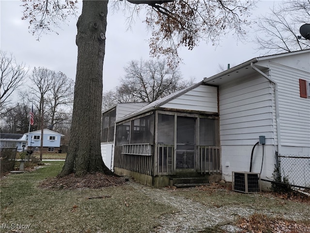 view of property exterior with a sunroom and cooling unit