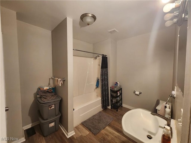 bathroom featuring hardwood / wood-style flooring, sink, and shower / tub combo