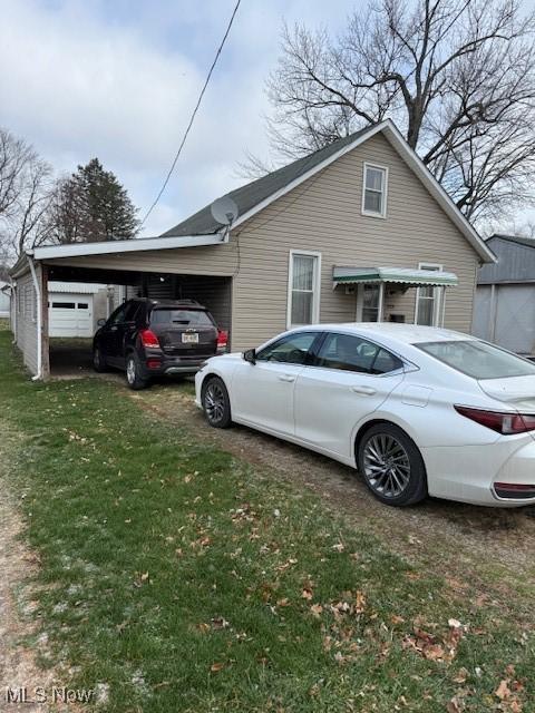 view of side of property featuring a lawn and a carport