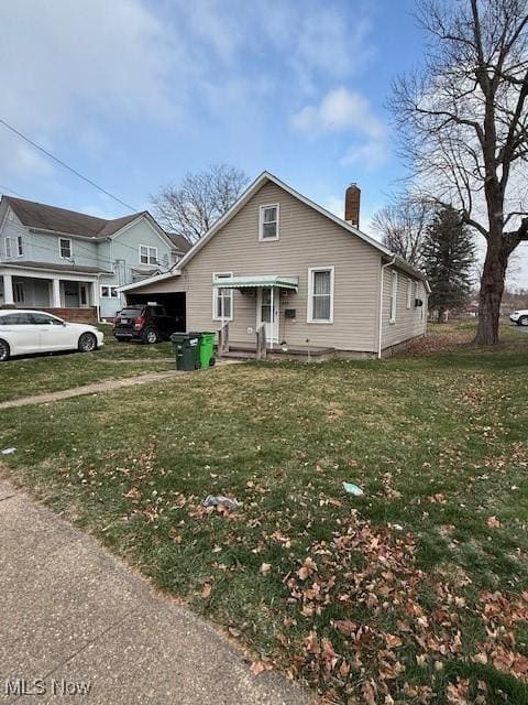 view of front of house with a front lawn and a carport