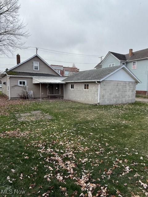 back of house featuring a lawn