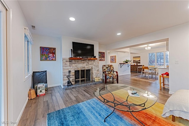 living room featuring hardwood / wood-style floors and a stone fireplace