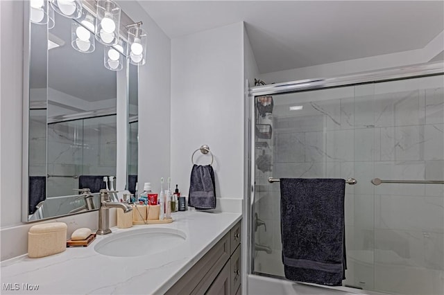 bathroom with a shower with door and vanity