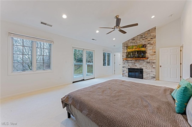 carpeted bedroom with access to outside, multiple windows, ceiling fan, and a fireplace